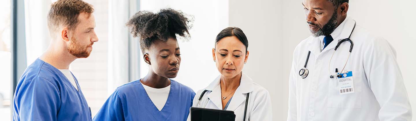 A group of medical professionals looking at a tablet