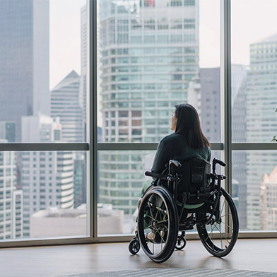 Disabled woman in wheelchair enjoying the view from her high rise apartment